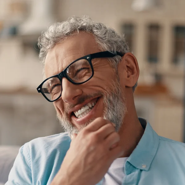 senior man scratching his chin, laughing and smiling