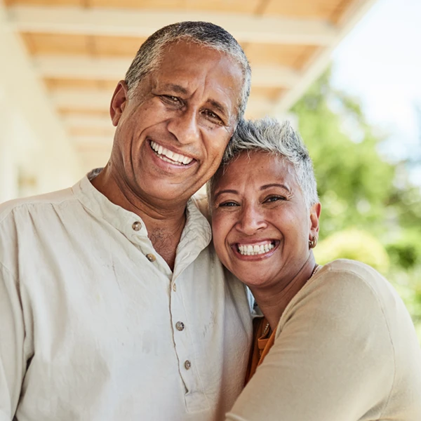 mature couple outdoors on a patio hugging and smiling