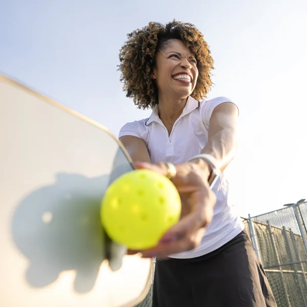mature woman serving during pickleball