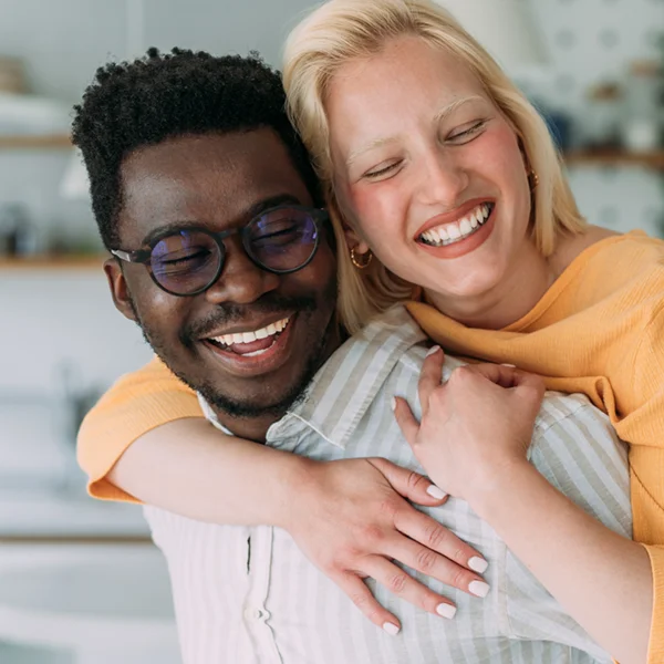 young couple embracing and smiling with great teeth